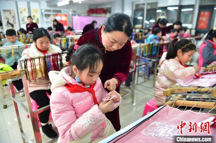 江西省級(jí)非遺豫章繡傳承人手把手指導(dǎo)小學(xué)生繡制2022年北京冬奧會(huì)吉祥物“冰墩墩”形象?！∮髟屏?攝