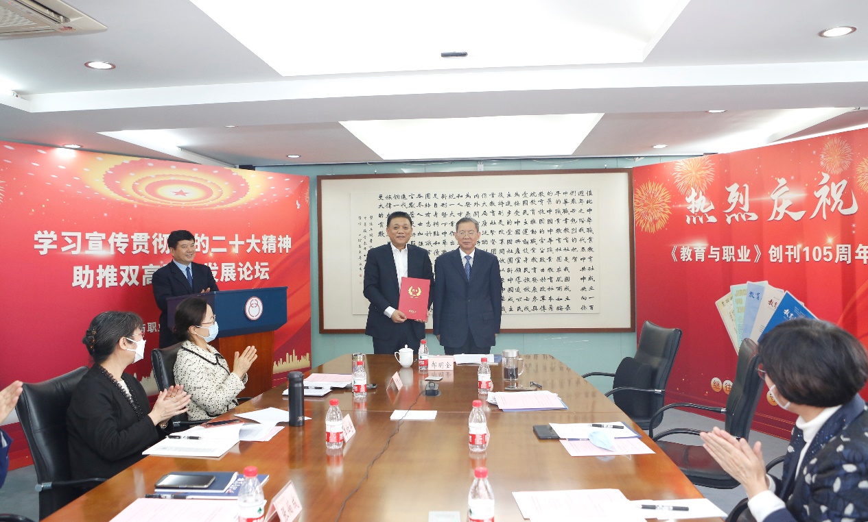 郝明金為《教育與職業(yè)》雜志編委代表陳曉明頒發(fā)聘書(shū)。中華職教社供圖