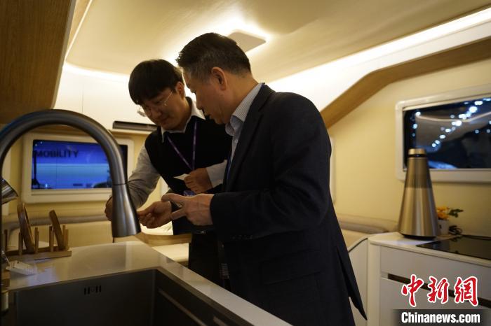 圖為參展商向觀眾介紹房車內(nèi)部設(shè)計?！⑿?攝