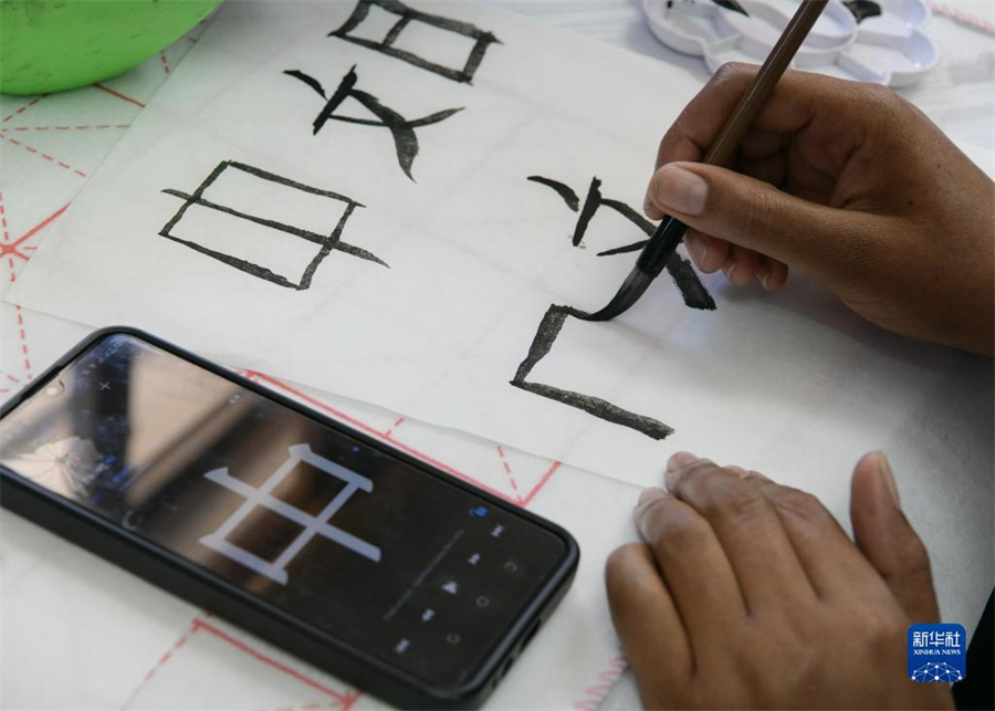 4月18日，肯尼亞學(xué)生在內(nèi)羅畢大學(xué)孔子學(xué)院舉辦的活動(dòng)上寫毛筆字?？夏醽唭?nèi)羅畢大學(xué)孔子學(xué)院18日舉辦“中文，增進(jìn)文明對(duì)話”主題活動(dòng)，慶祝即將到來的第14個(gè)聯(lián)合國中文日。肯尼亞學(xué)生參與互動(dòng)，進(jìn)行書法、剪紙、唱中文歌等活動(dòng)。新華社記者 韓旭 攝