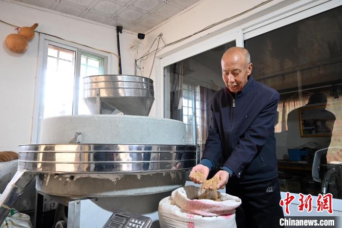 李家莊村民谷文朝重拾父輩的手藝，做起石磨面粉的營生?！〉杂鸺?攝