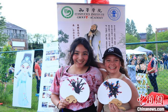 孩子們展示自己的吹墨畫團扇作品?！◆斻肟鬃訉W院供圖