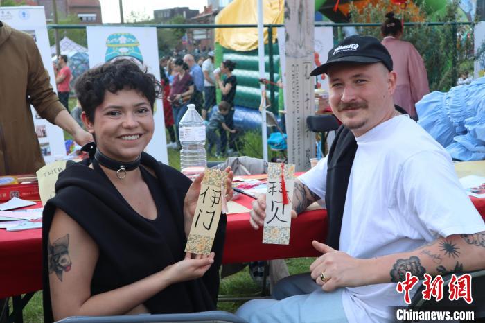 當?shù)孛癖娫跐h字體驗工作坊展示自己手寫的中文名書簽?！◆斻肟鬃訉W院供圖