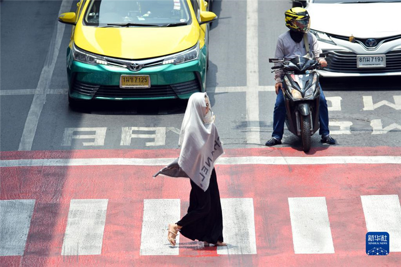 5月17日，行人在泰國曼谷街頭用圍巾遮陽。新華社發(fā)（拉亨攝）