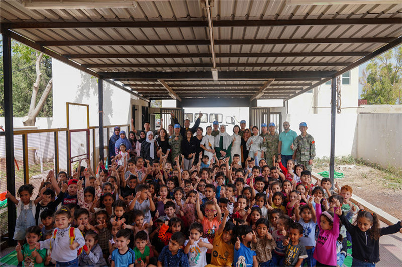 當(dāng)?shù)貢r(shí)間5月30日，黎巴嫩南部庫雷拉公立小學(xué)，“六一”國際兒童節(jié)前夕，中國第21批赴黎維和多功能工兵分隊(duì)官兵看望慰問學(xué)校師生，并開展文化交流活動，圖為我維和官兵同師生合影。李竹林?jǐn)z