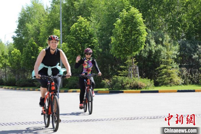 亞信副秘書長(zhǎng)遲方(右一)與聯(lián)合國(guó)駐哈協(xié)調(diào)員在騎行活動(dòng)中?！喰琶貢幑﹫D