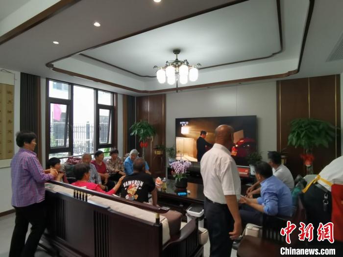 親友們集中在費(fèi)俊龍家中觀看返程的視頻。　鐘升 攝