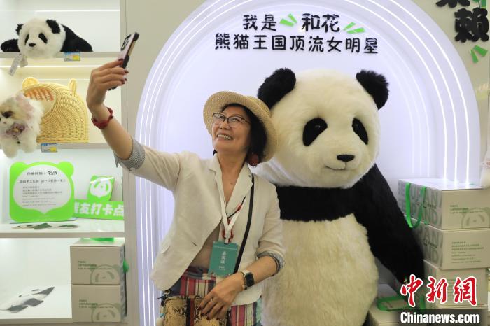 美國華視總裁楊蓮花與大熊貓文創(chuàng)產品合影。　王磊 攝