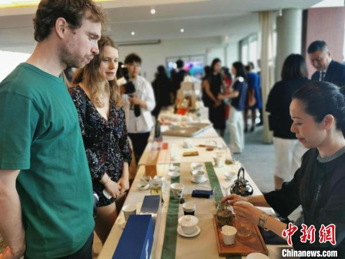 現(xiàn)場(chǎng)觀眾觀看中國(guó)展臺(tái)茶藝表演、了解茶文化?！【笜?攝