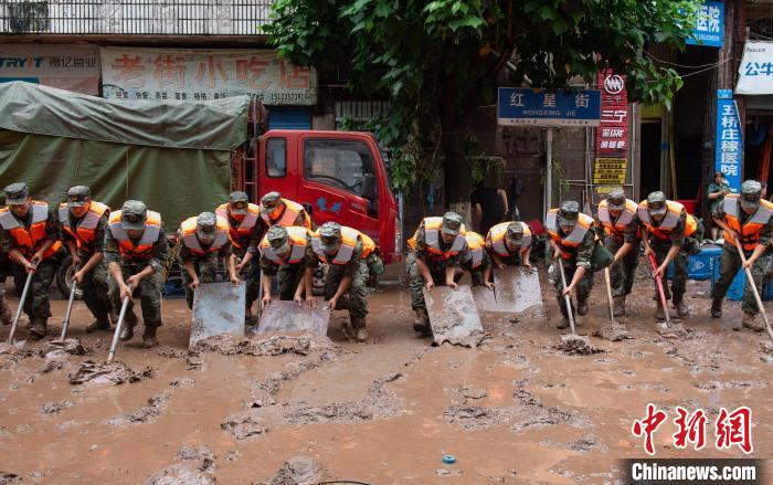 7月4日，萬州區(qū)五橋街道，武警官兵清理街道上的淤泥?！∪矫宪?攝