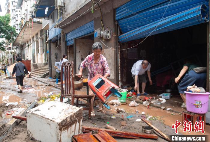 7月4日，萬州區(qū)五橋街道，洪水退去后，居民搶救生活物資?！∪矫宪?攝