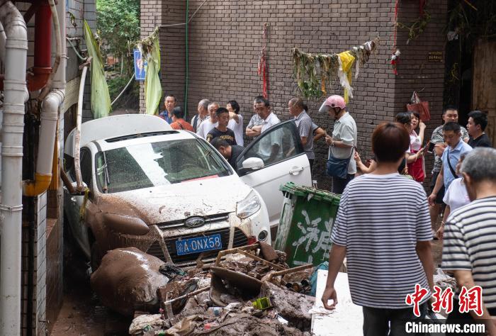 7月4日，萬州區(qū)五橋街道，居民救援受困的私家車。　冉孟軍 攝