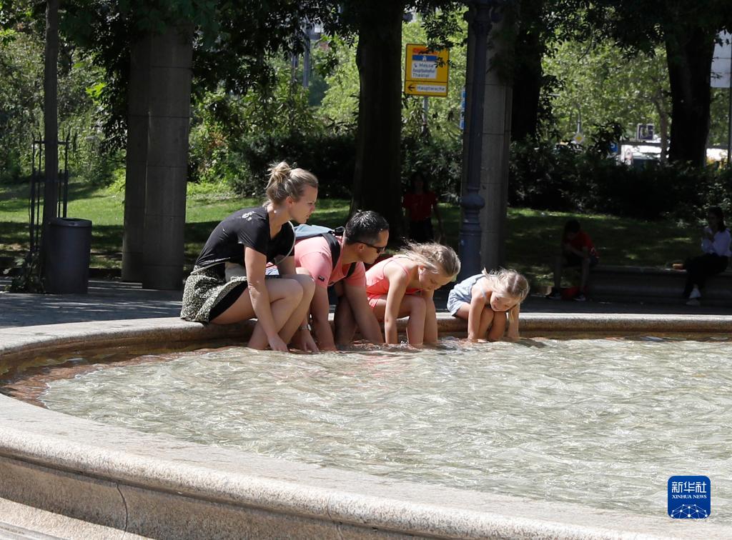 7月8日，人們在德國法蘭克福的一處噴泉玩水。近日，德國法蘭克福逐漸迎來暑熱天氣。新華社記者 張帆 攝