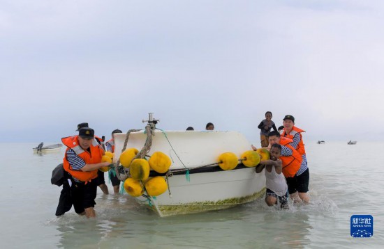 7月21日，中國(guó)海軍“和平方舟”號(hào)醫(yī)院船醫(yī)護(hù)人員涉水登島，前往基里巴斯一診療點(diǎn)。新華社記者 黎云 攝