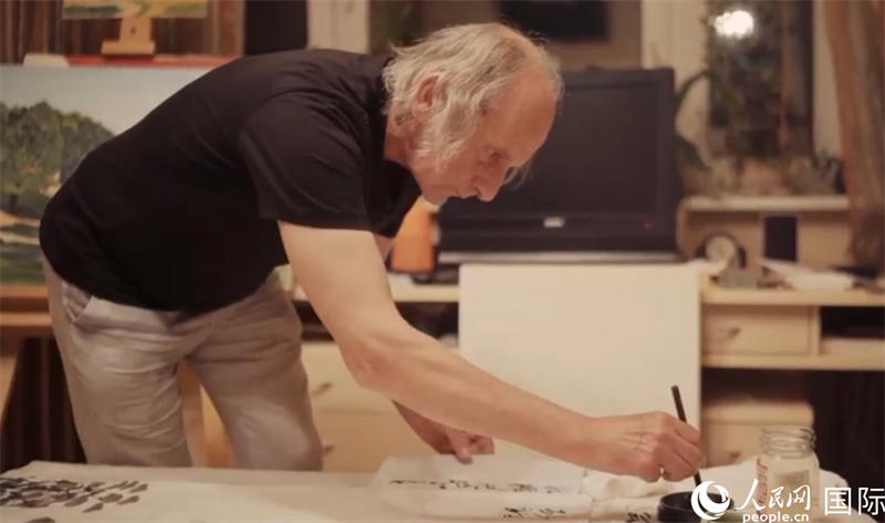 伊戈爾·布爾東諾夫在畫作上題詞。人民網(wǎng)記者 馬天翼攝