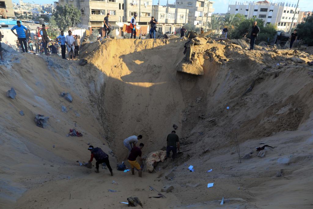 10月16日，在加沙地帶南部城市汗尤尼斯，人們?cè)谠庖陨幸u擊后的建筑廢墟中救援傷者。 新華社發(fā)（亞西爾·庫(kù)迪 攝）