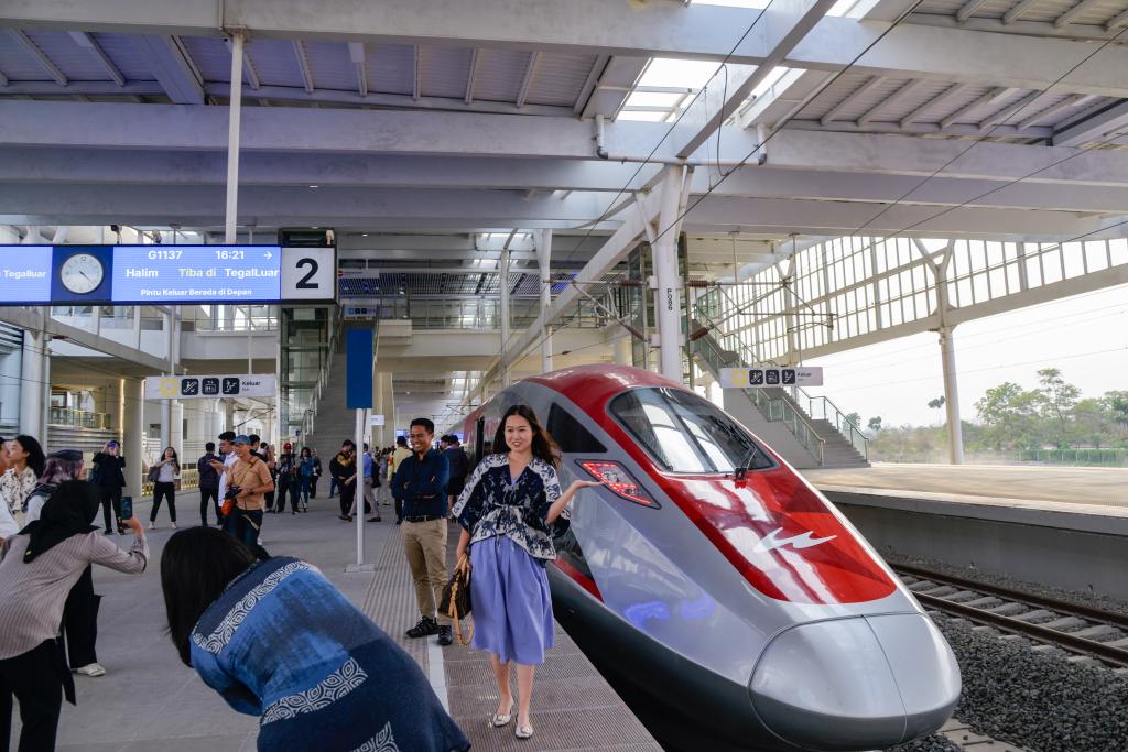 10月17日，在印度尼西亞萬隆德卡魯爾站，乘客在站臺(tái)上和雅萬高鐵高速動(dòng)車組列車合影。