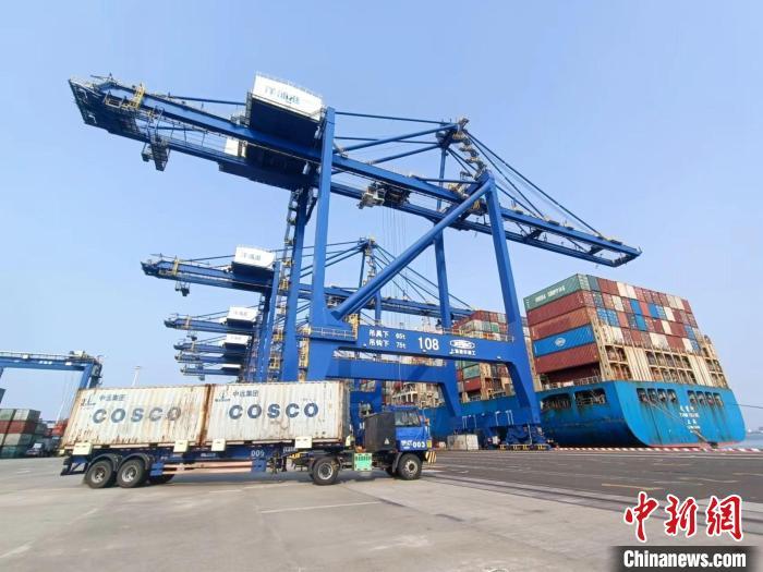 圖為海南洋浦國際集裝箱碼頭，卡車將集裝箱從后方堆場運(yùn)往碼頭裝卸區(qū)?！?jiān)潞?攝
