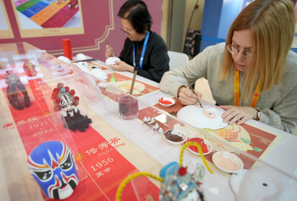 10月16日，在第三屆“一帶一路”國(guó)際合作高峰論壇新聞中心，來(lái)自比利時(shí)的記者（右）體驗(yàn)畫(huà)京劇臉譜。新華社記者 王毓國(guó) 攝