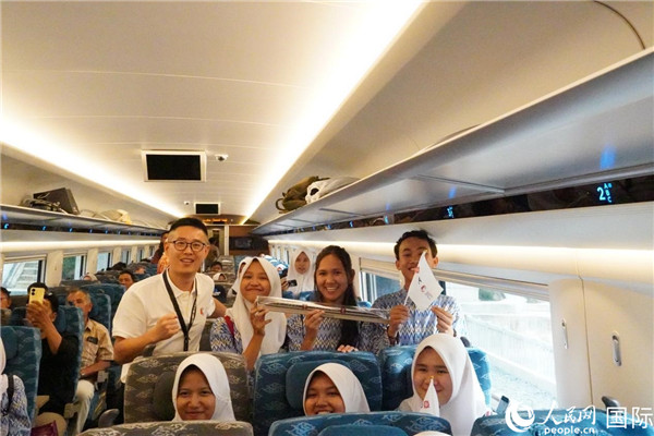 第一次乘坐雅萬高鐵動車組的學生們與動車組模型合影。人民網(wǎng)記者曹師韻攝