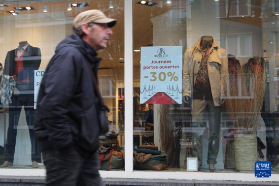   10月31日，一名男子從比利時布魯塞爾一家貼有打折信息的店鋪前走過。新華社記者 趙丁喆 攝