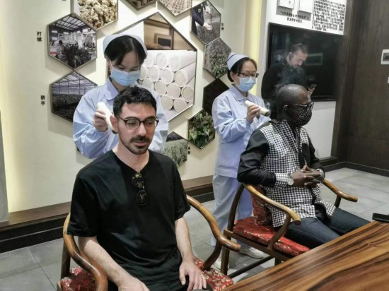 2023“一帶一路”媒體合作論壇聯(lián)合采訪團(tuán)團(tuán)員在九牛草展示館體驗(yàn)艾灸。（本報(bào)記者 黃超攝）