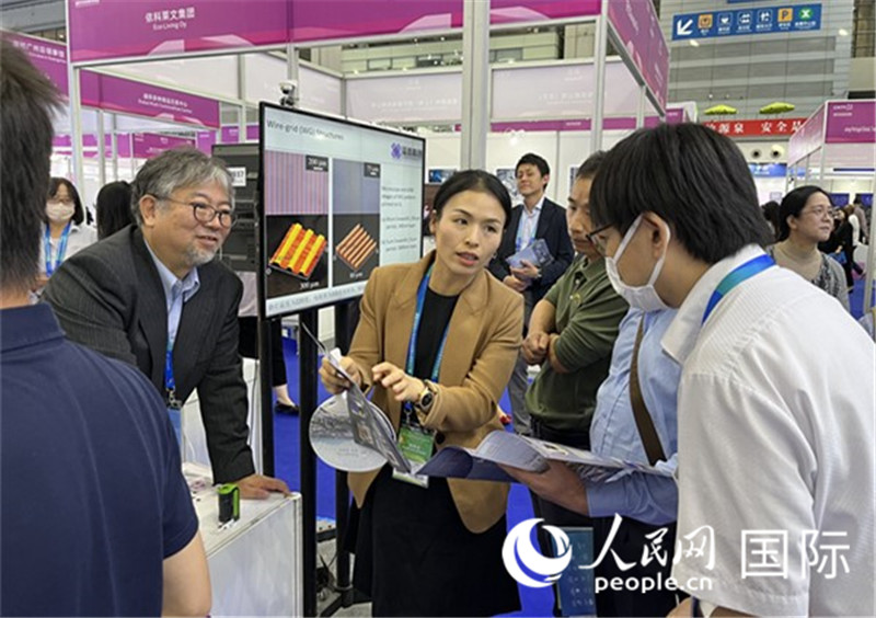 工作人員向參觀者介紹超級噴墨技術(shù)。（人民網(wǎng)記者 陳思攝）