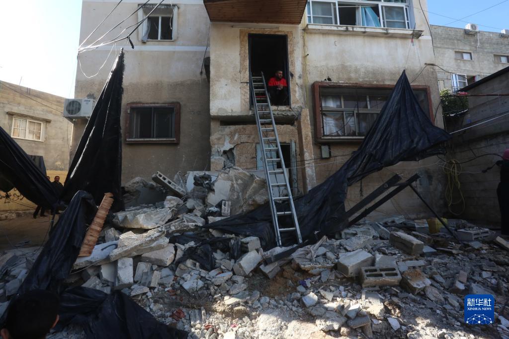 12月17日，在約旦河西岸城市圖勒凱爾姆附近的一處難民營，人們查看在沖突中損毀的房屋。新華社發(fā)（尼達爾·艾仕塔耶?dāng)z）