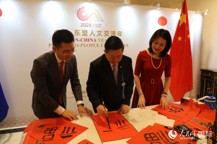 東盟秘書長高金洪（中）在活動現(xiàn)場寫福字。人民網(wǎng)記者曹師韻攝