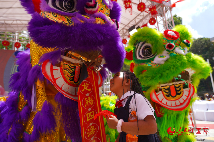 小朋友與舞獅表演者互動(dòng)。人民網(wǎng)記者 黃煒鑫攝