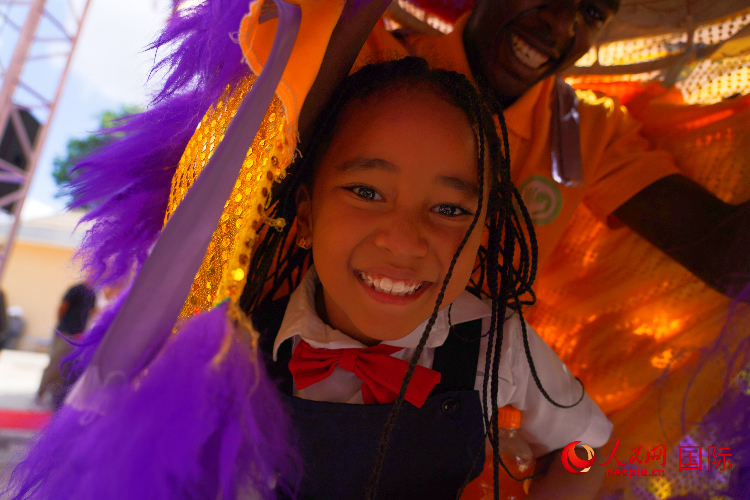 一名小朋友在與舞獅表演者互動(dòng)。人民網(wǎng)記者 黃煒鑫攝