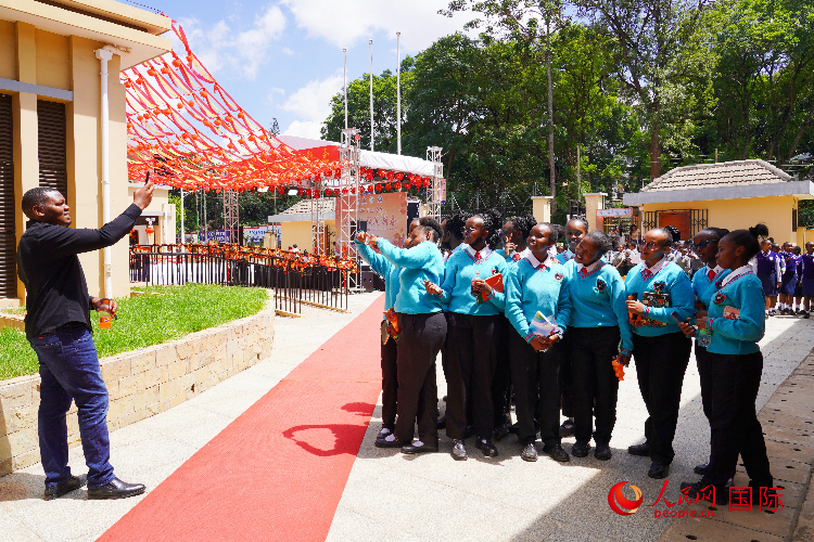 一名老師在給學(xué)生拍照留念。人民網(wǎng)記者 黃煒鑫攝