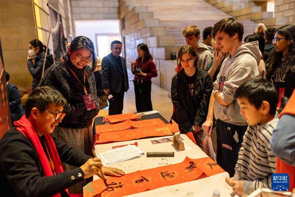 2月11日，書(shū)法家在美國(guó)費(fèi)城藝術(shù)博物館舉行的龍年迎新春活動(dòng)上為參觀(guān)者書(shū)寫(xiě)對(duì)聯(lián)。新華社發(fā)（周煥新攝）