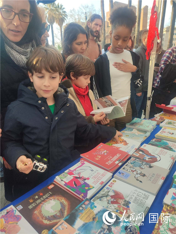 印刷精美的中國傳統(tǒng)文化叢書吸引了小游客的注意。人民網(wǎng)記者鄭彬攝