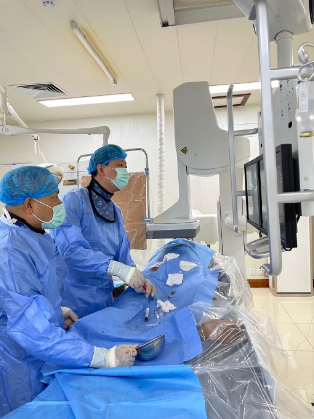 李凱教授（右）和劉海濤教授（左）為患者行TACE手術(shù)。中國(guó)駐老撾大使館供圖