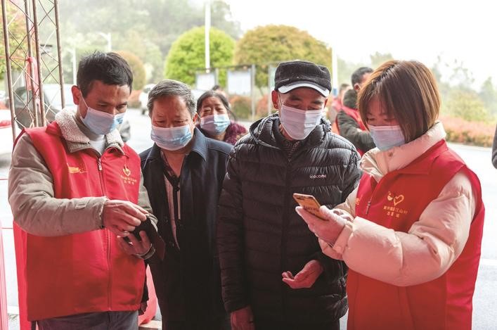 長沙縣黨員志愿者正在幫助參與核酸檢測的群眾掃描“場所碼”。劉思源 攝