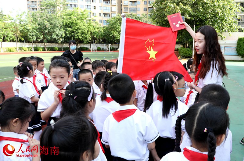 老師向少先隊員展示隊旗。人民網(wǎng) 符武平攝