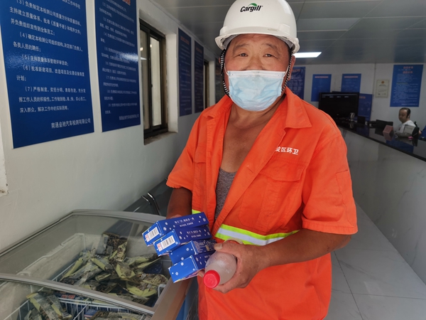 1環(huán)衛(wèi)工倪建宏小憩后，為還同事帶去冷飲。人民網(wǎng)記者王繼亮攝