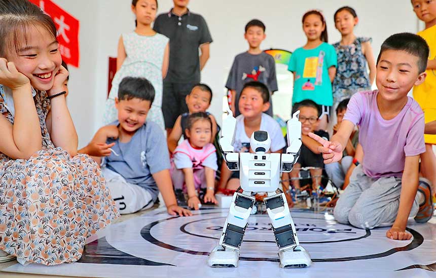 2022年7月19日，河北省秦皇島市海港區(qū)白塔嶺街道秦皇半島第二社區(qū)內(nèi)，小朋友正在觀看“機(jī)器人跳舞”。 曹建雄攝