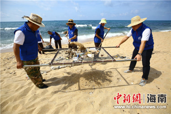 環(huán)保志愿者用篩網(wǎng)“淘”出海灘上的垃圾。