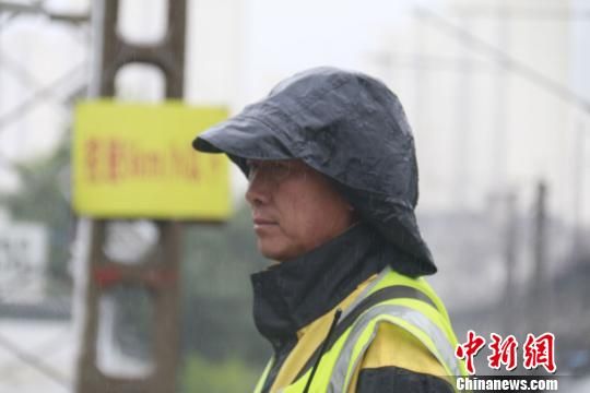 蘭州西工務(wù)段蘭州線路車(chē)間防護(hù)員雨中巡查?！⊥豕廨x 攝
