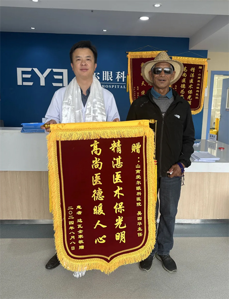 達(dá)瓦老人向吳四華（左）贈(zèng)送錦旗。受訪者供圖