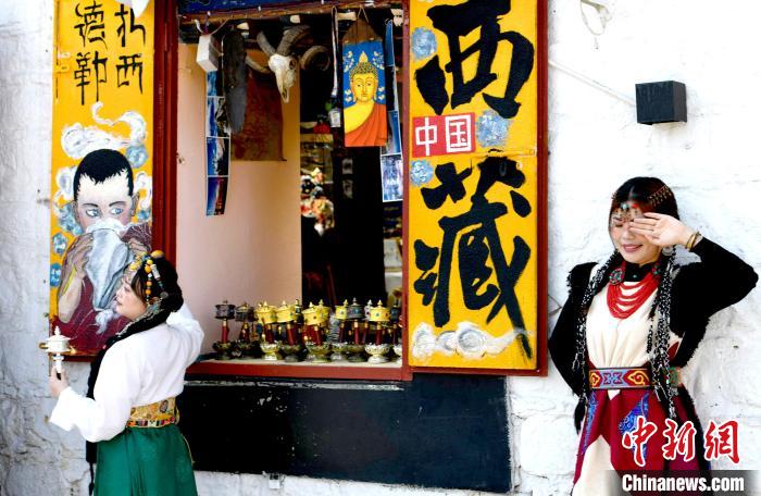 4月17日，游客身著藏式元素服裝在拉薩八廓街拍照留念。　李林 攝