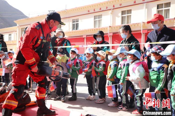 圖為消防指戰(zhàn)員為學(xué)生講解、演示先進(jìn)救援裝備?！≮w琳 攝