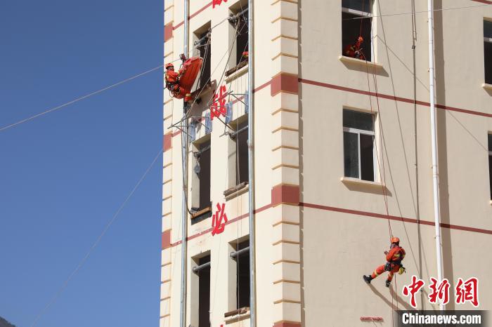 圖為消防指戰(zhàn)員進(jìn)行繩索救援演練。　朱科熹 攝