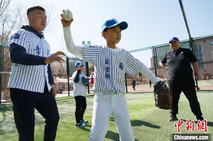 圖為教練指導(dǎo)小棒球手?jǐn)S球技術(shù)?！●R銘言 攝