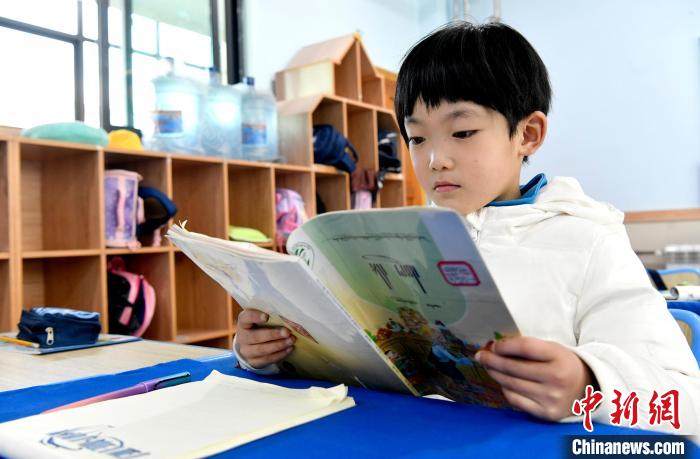 3月14日，西藏拉薩市第一小學(xué)一年級六班學(xué)生丁增樂吉在閱讀藏語課本?！±盍?攝
