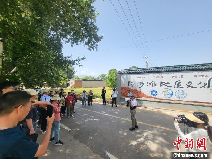 圖為中國(guó)地質(zhì)大學(xué)(北京)教授張緒教介紹村落情況?！『衍?攝