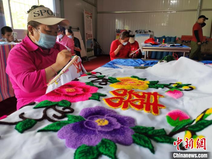 圖為婦女制作青繡?！?zhí)砀?攝