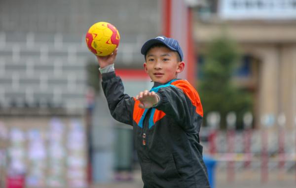 在高原上教孩子們打手球，“慢慢兒來(lái)，甭著急！”